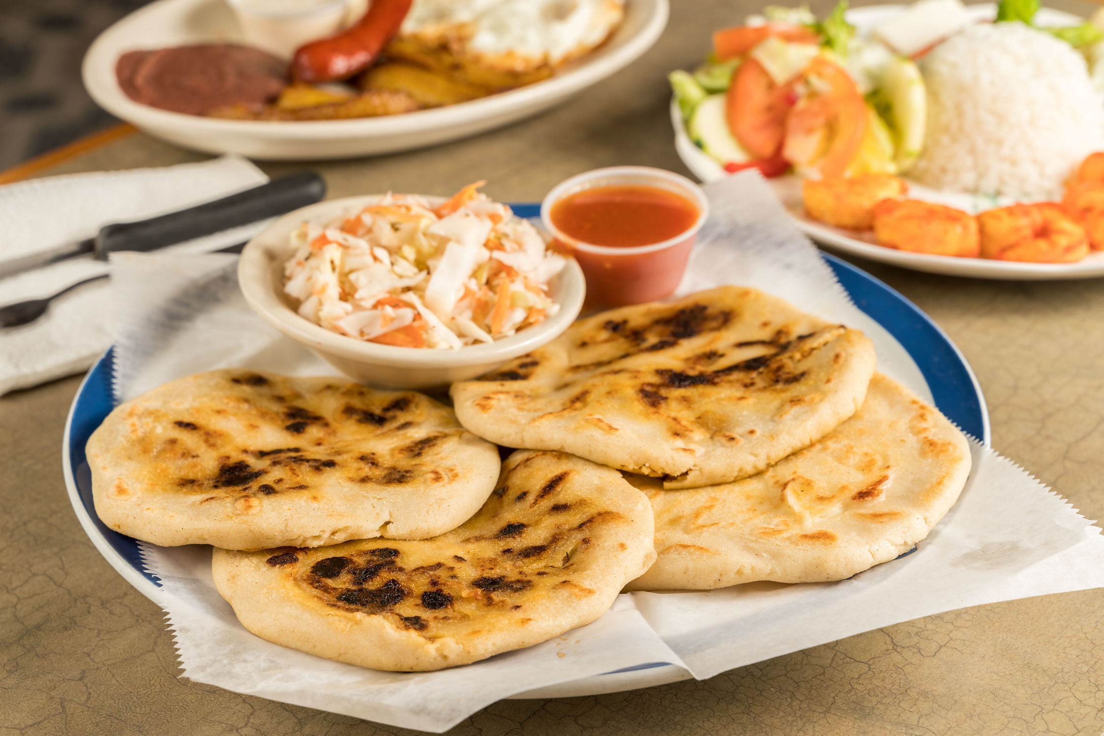 a dish of pupusas  and others mexican food on the table